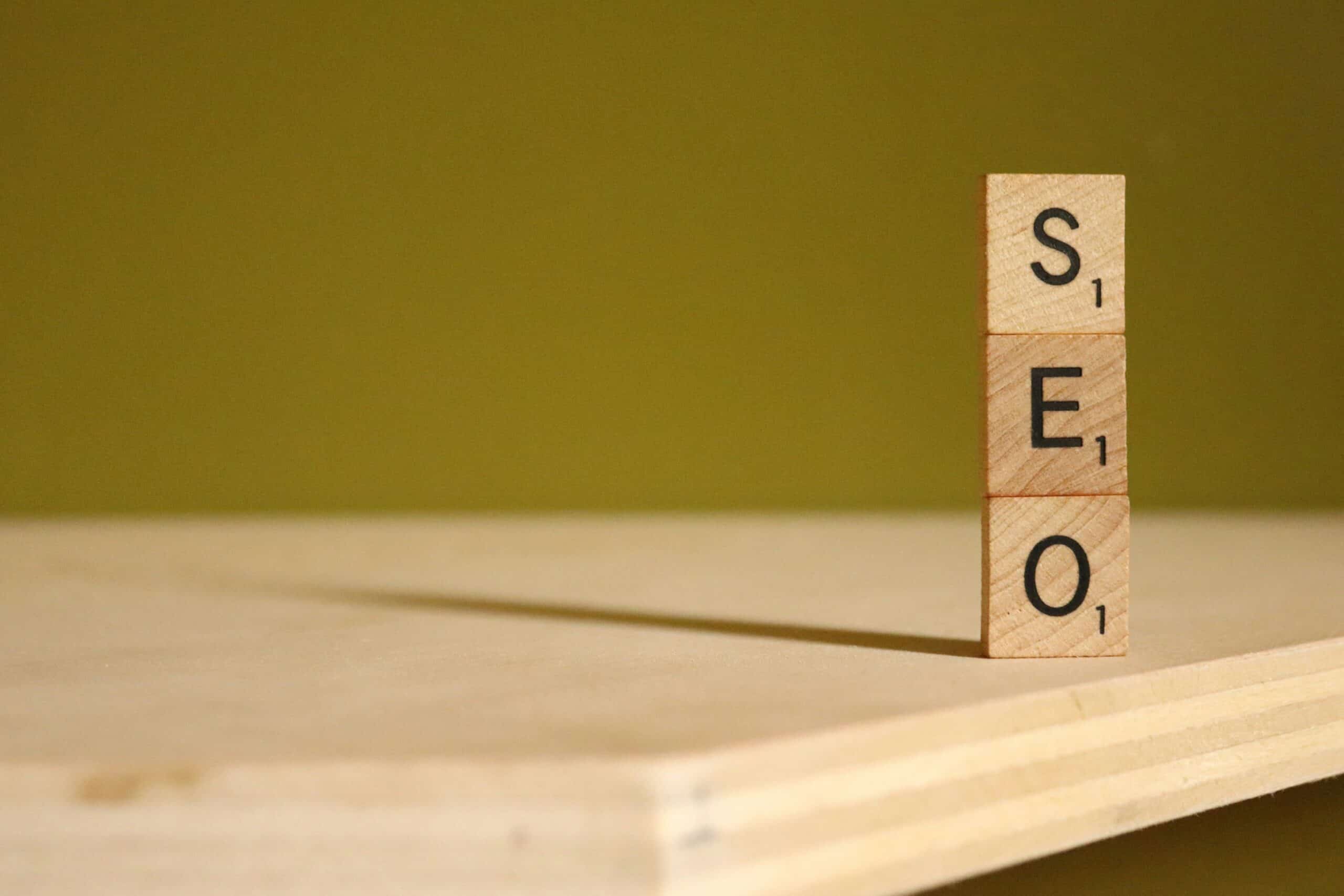 The letters SEO are balanced on top of one another using Scrabble tiles