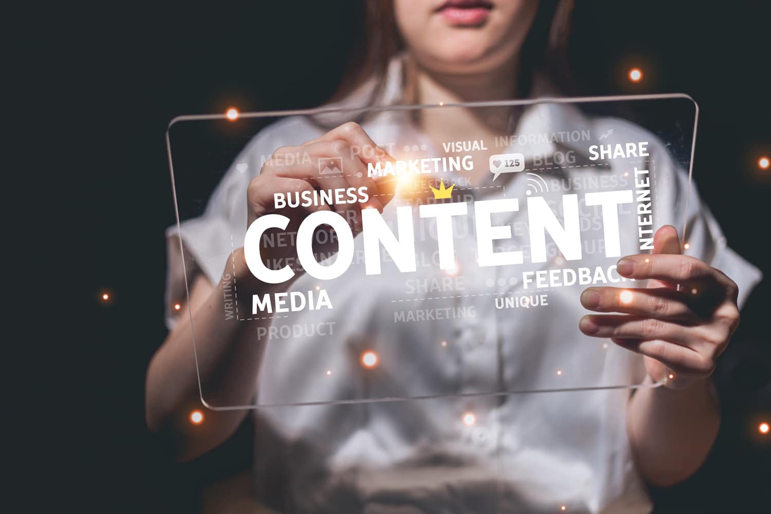 A woman holds a tablet displaying the words 'business', 'content', 'marketing', 'innovation' and other similar words.